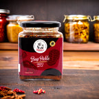 Jar of beef pickle with a brand logo on a wooden surface and shelves with more jars in the background.