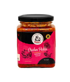 Jar of chicken pickle with pink label and black lid on a white background