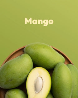 Green mangoes in a wooden bowl with a green background and the word 'Mango' displayed.