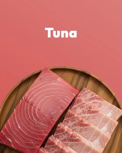 Raw tuna slices on a wooden plate with 'Tuna' text on a pink background
