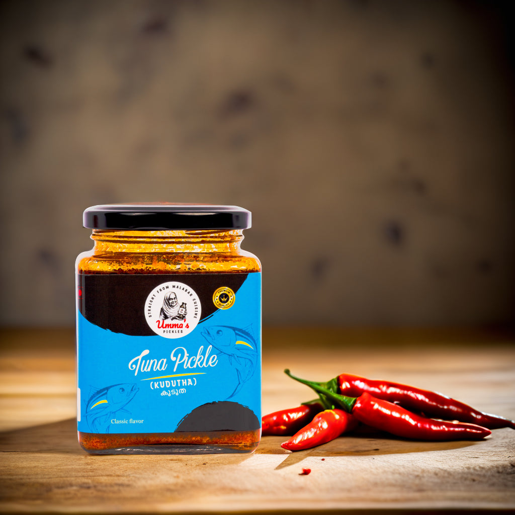 Jar of tuna pickle with a blue label on a wooden surface with red peppers.